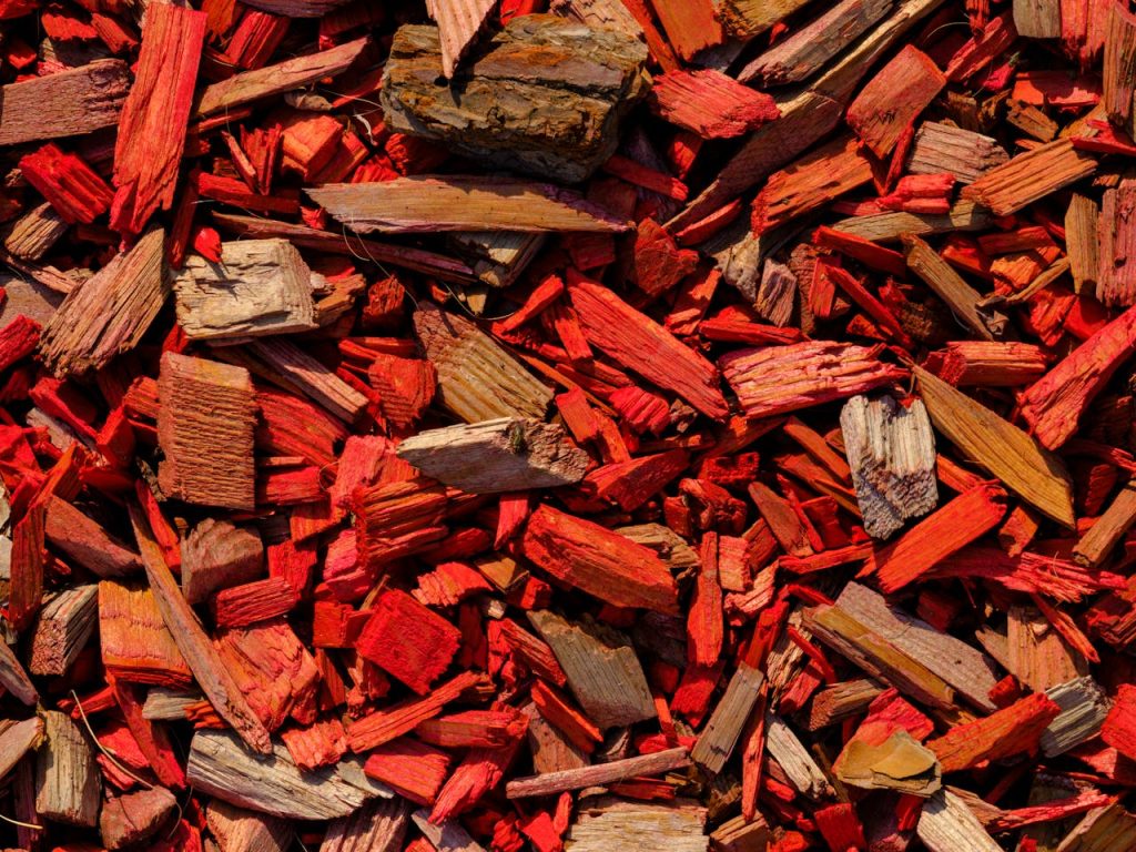 Close-up shot of vibrant red wood mulch, ideal for gardening and design projects.